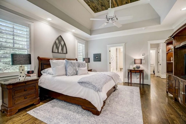 bedroom featuring ceiling fan, dark hardwood / wood-style floors, a raised ceiling, and connected bathroom