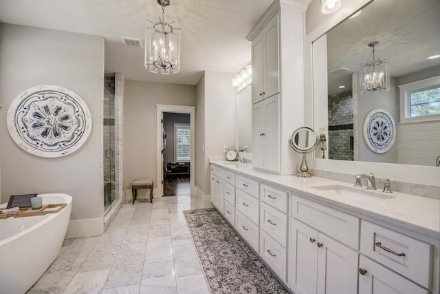 bathroom with a chandelier, vanity, and separate shower and tub