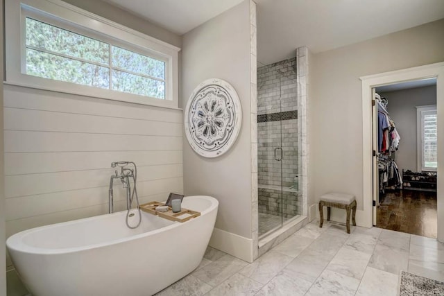 bathroom featuring plus walk in shower, hardwood / wood-style floors, and plenty of natural light