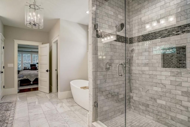 bathroom with a notable chandelier and separate shower and tub