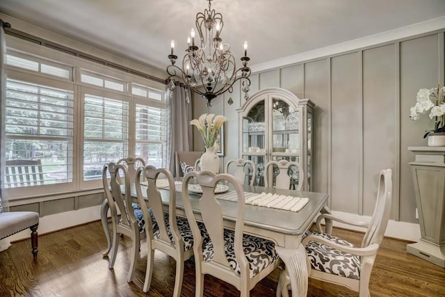 dining space featuring hardwood / wood-style flooring and a chandelier