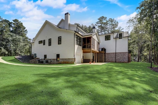 rear view of property featuring a lawn and a sunroom