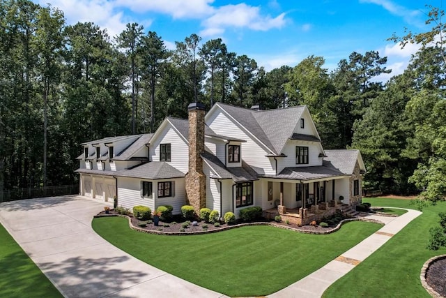 view of front of house with a front yard, a garage, and covered porch