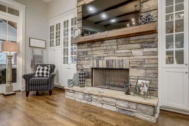 sitting room with a fireplace and hardwood / wood-style floors