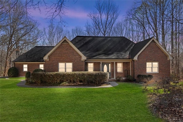 view of front facade with a front yard and brick siding