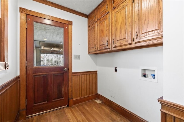 laundry room featuring cabinet space, hookup for a washing machine, electric dryer hookup, and a wainscoted wall