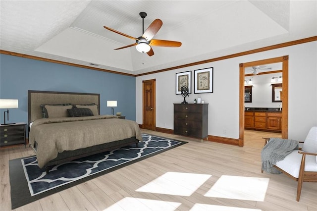 bedroom with a tray ceiling, visible vents, light wood-style flooring, and baseboards