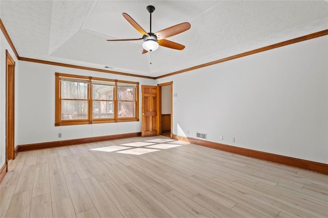 interior space featuring a textured ceiling, light wood-style flooring, visible vents, a tray ceiling, and crown molding