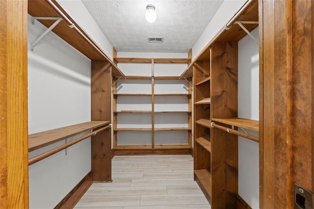 walk in closet with light wood-style flooring and visible vents