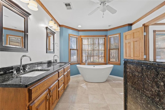 bathroom featuring ornamental molding, a sink, visible vents, and baseboards