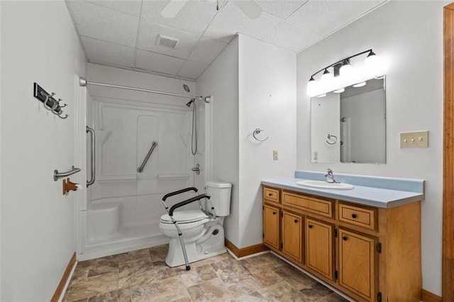 full bathroom with a shower, a drop ceiling, vanity, and toilet