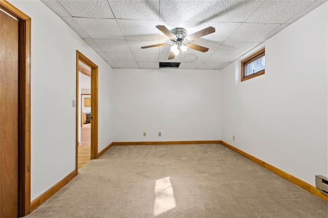 spare room with visible vents, baseboards, a drop ceiling, light colored carpet, and ceiling fan