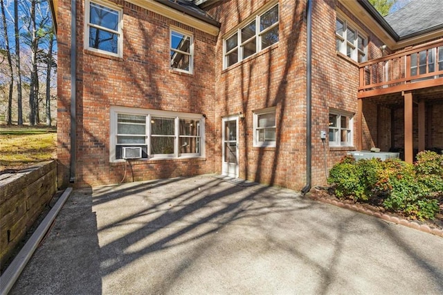 rear view of house featuring cooling unit and brick siding