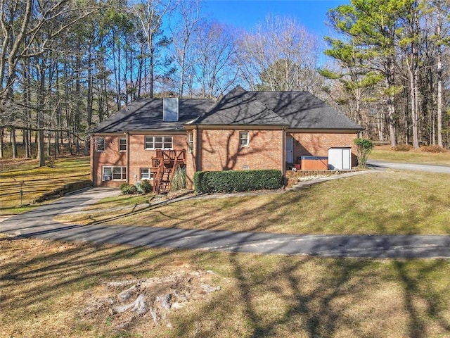 view of front of house with a front lawn, a chimney, fence, and brick siding