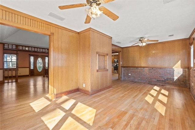 interior space featuring visible vents, wood walls, and light wood finished floors