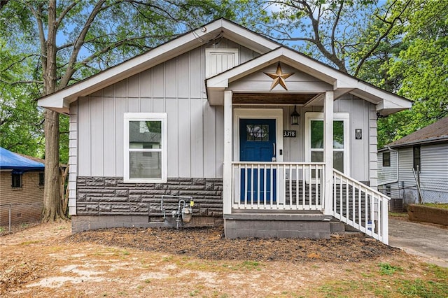 view of front facade featuring fence, a porch, and board and batten siding