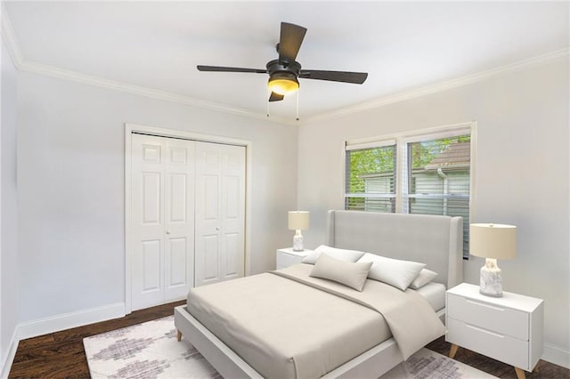 bedroom featuring wood finished floors, a closet, crown molding, and baseboards