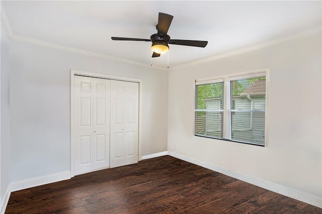unfurnished bedroom featuring baseboards, dark wood-style floors, a closet, and ornamental molding