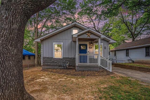 bungalow featuring stone siding and board and batten siding