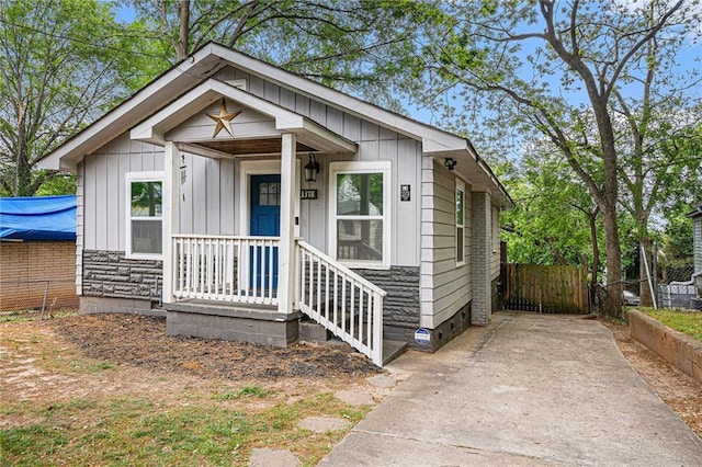 bungalow-style home featuring fence and board and batten siding