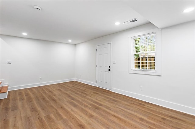 empty room featuring visible vents, recessed lighting, baseboards, and wood finished floors