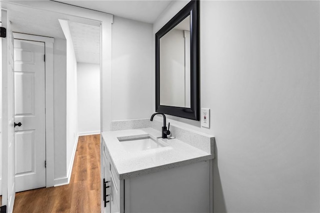 bathroom featuring vanity, baseboards, and wood finished floors