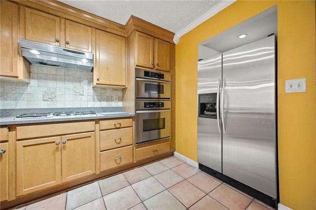 kitchen with light tile patterned floors, backsplash, a textured ceiling, crown molding, and stainless steel appliances