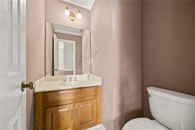 bathroom with crown molding, vanity, and toilet