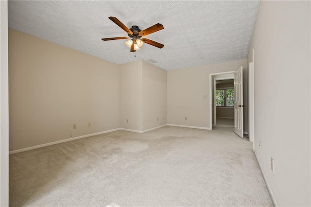 unfurnished room with a textured ceiling, light carpet, and ceiling fan