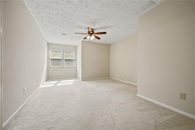 empty room with ceiling fan, a textured ceiling, and light colored carpet