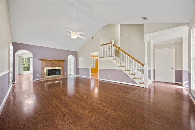 unfurnished living room featuring dark hardwood / wood-style flooring, high vaulted ceiling, ceiling fan, and a fireplace