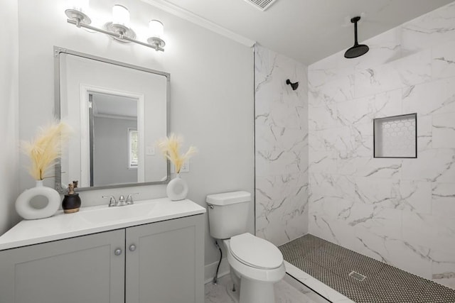 bathroom with tiled shower, vanity, toilet, and ornamental molding