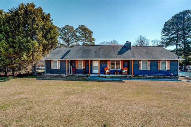 single story home featuring a porch, a chimney, and a front yard