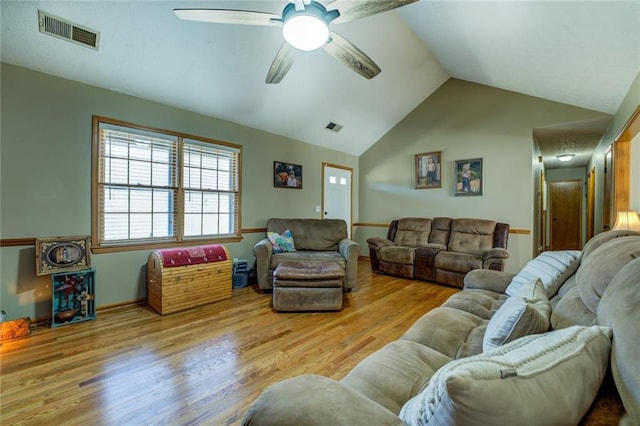 living area with a ceiling fan, visible vents, vaulted ceiling, and wood finished floors