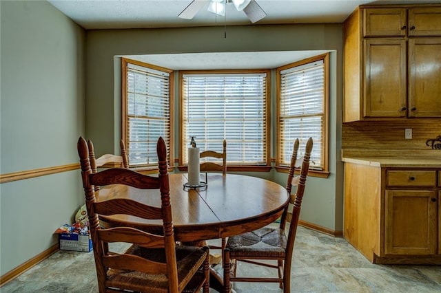 dining area featuring baseboards and a ceiling fan