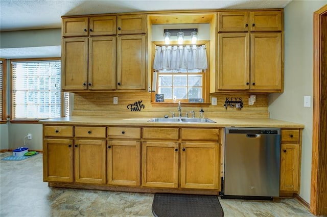 kitchen with plenty of natural light, light countertops, dishwasher, and a sink