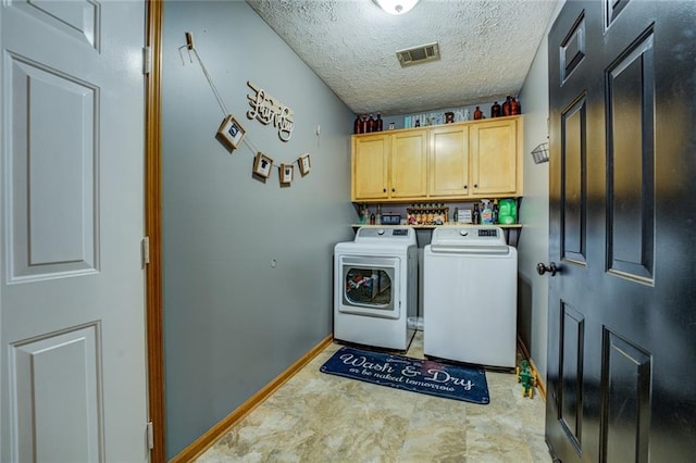 laundry area featuring cabinet space, baseboards, visible vents, a textured ceiling, and separate washer and dryer