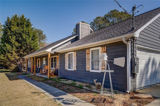 view of side of property featuring a porch, a chimney, and a shingled roof