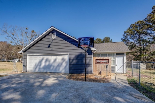 view of front of property with aphalt driveway, roof with shingles, fence, and an outdoor structure