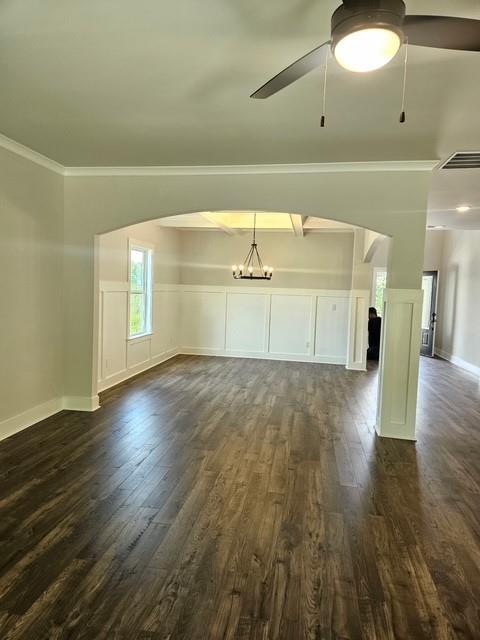 222 Silvercrest Dr, Acworth, GA 30101 - unfurnished living room with dark wood-type flooring, ceiling fan, crown molding, a chandelier, and baseboards