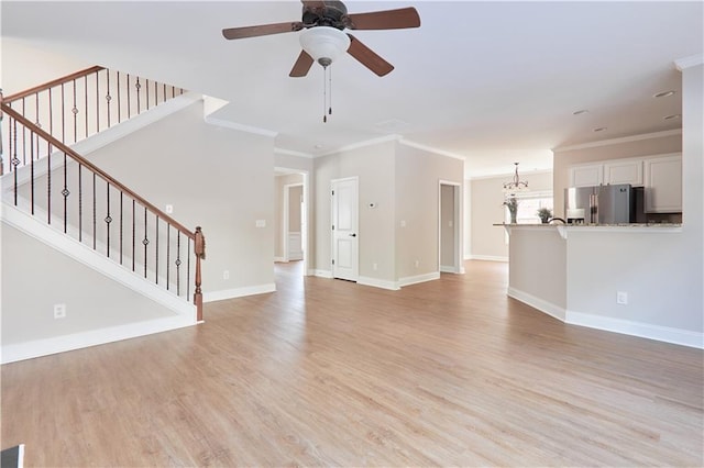 unfurnished living room featuring a ceiling fan, crown molding, stairway, baseboards, and light wood-style flooring