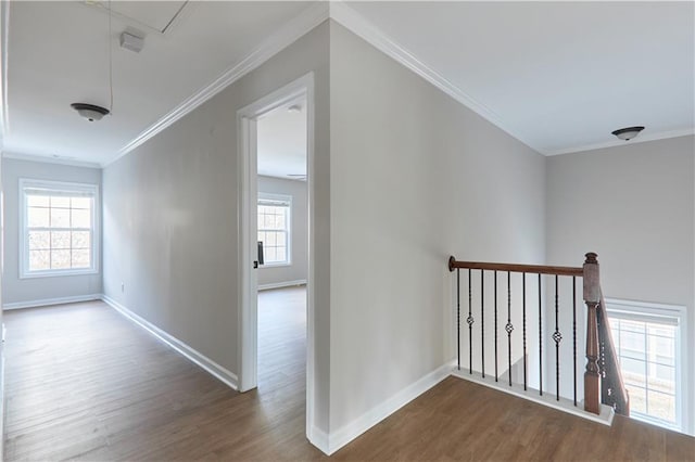 hallway featuring crown molding, attic access, baseboards, an upstairs landing, and wood finished floors