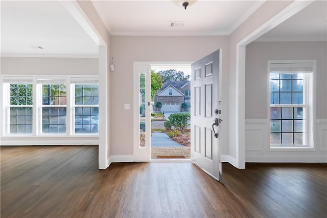 entryway featuring ornamental molding, wainscoting, dark wood finished floors, and visible vents