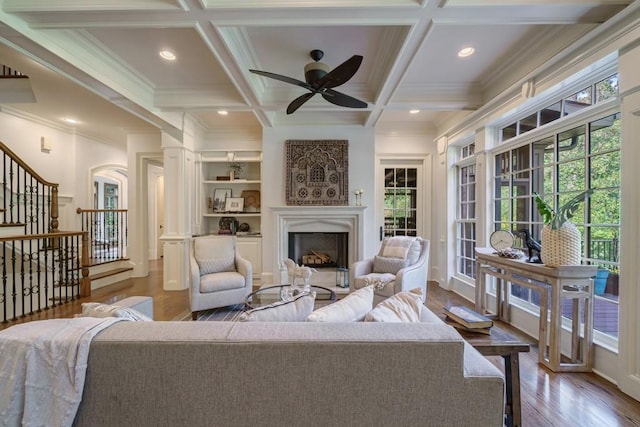 living room with coffered ceiling, ceiling fan, beam ceiling, and hardwood / wood-style flooring