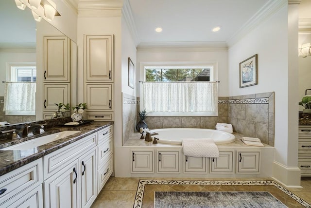 bathroom with a healthy amount of sunlight, tile floors, a bath, and vanity