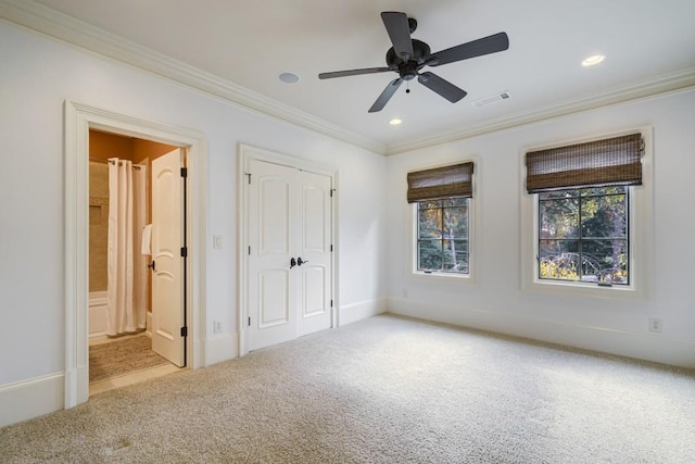 unfurnished bedroom featuring ceiling fan, a closet, connected bathroom, light colored carpet, and ornamental molding