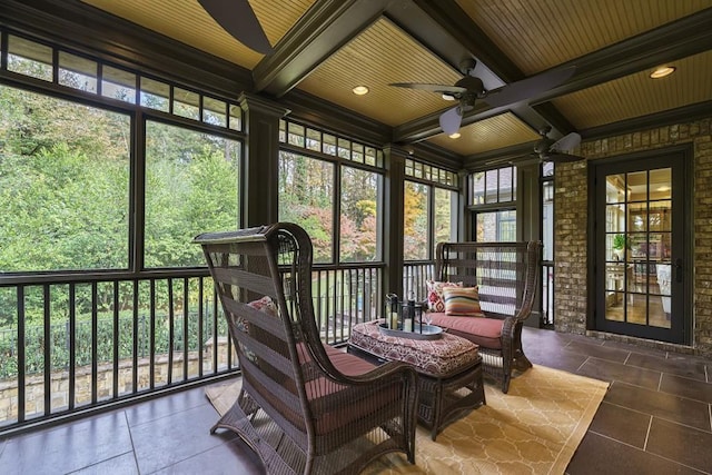 sunroom with plenty of natural light, ceiling fan, and beamed ceiling