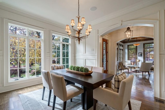 dining area featuring an inviting chandelier, crown molding, and wood-type flooring