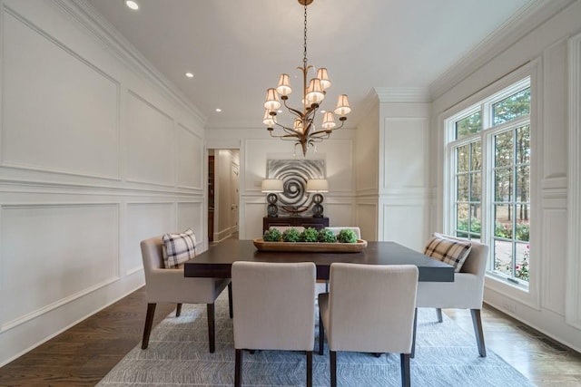 dining area with a notable chandelier, crown molding, and hardwood / wood-style floors