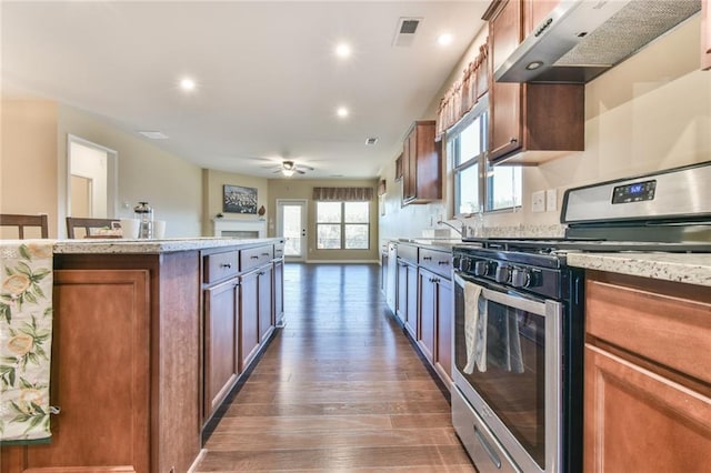 kitchen featuring gas stove, ceiling fan, dark hardwood / wood-style floors, extractor fan, and a kitchen island